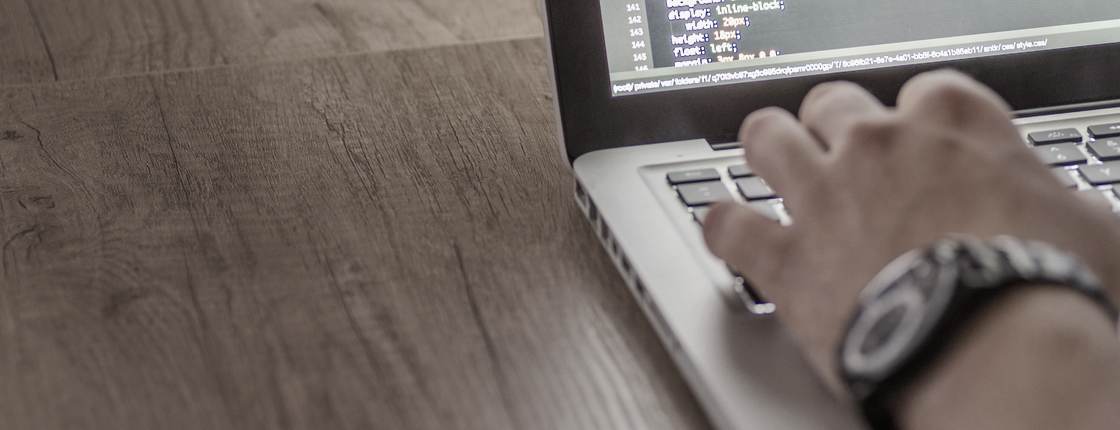 Escritorio de trabajo con un portátil mostrando código
